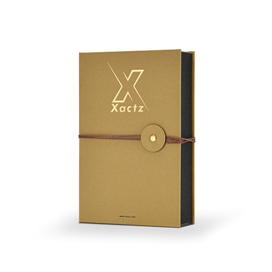 Angled front view of a custom rigid book style perfume gift box displaying the natural textured ochre yellow paper cover with gold foil logo and contrasting matte black inner box sides