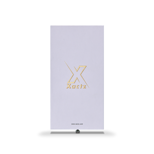 Front view of lavender-white Xactz rigid drawer box with gold foil logo and metal pull bead at base.