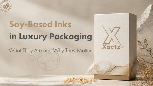 Custom luxury textured paper box with gold foil Xactz logo next to raw soybeans and eco-friendly soy-based inks blog banner.