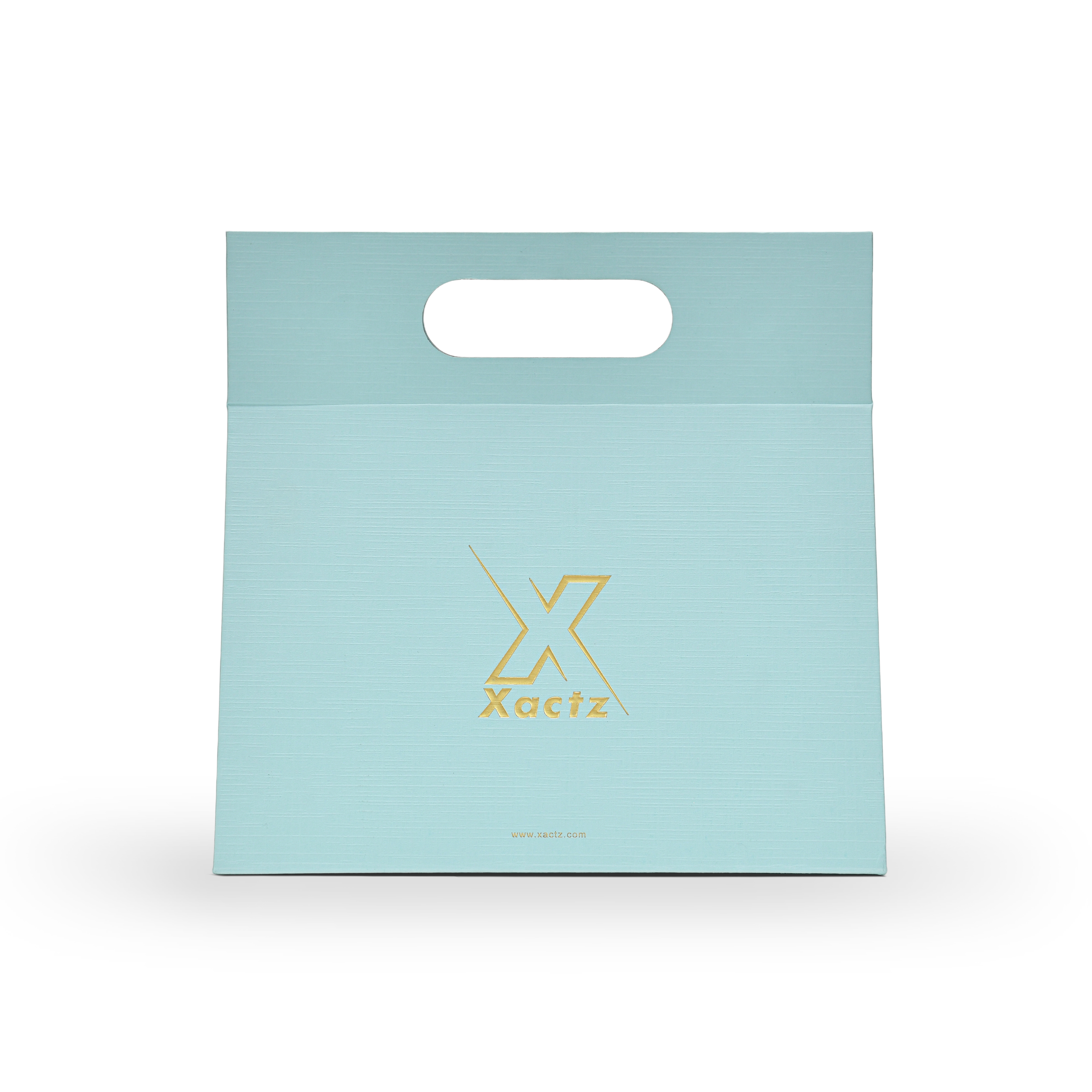 Custom foldable gift box bag with handle in sky blue linen specialty paper showing the full front panel with a centered embossed matte gold foil Xactz logo on the smooth linen texture surface and a die cut carry handle cutout at the top