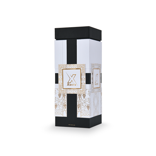 Three quarter angled view of a custom black rigid wine gift box with collared lid and base displaying the full gold foil geometric grape vine illustration wrapping around the white body panels with a matte black lid and collar