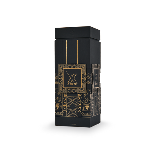 Three quarter angled view of a custom all black rigid wine gift box with collared lid and base displaying the gold foil grape vine and geometric pattern wrapping around all four black body panels with the debossed Xactz logo visible on the front and side panels