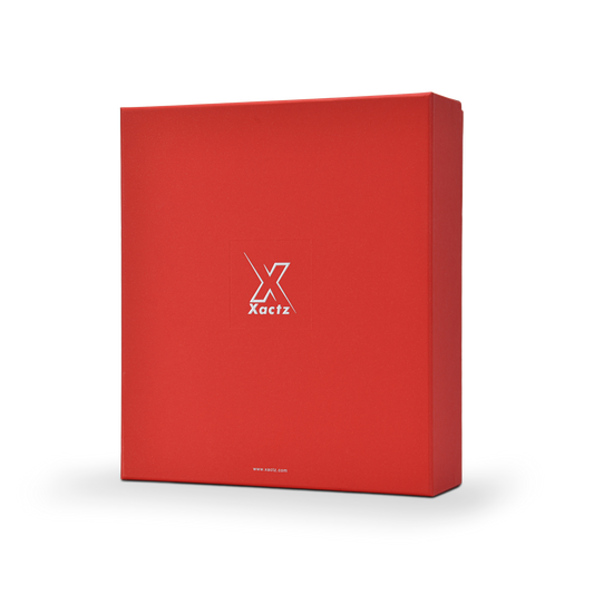 Three quarter angled view of a custom red lid and base gift box for cosmetics displaying the deep red star rain specialty paper surface wrapping the full lid and base with the embossed bright silver foil Xactz logo centered on the front panel and silver foil website detail at the base