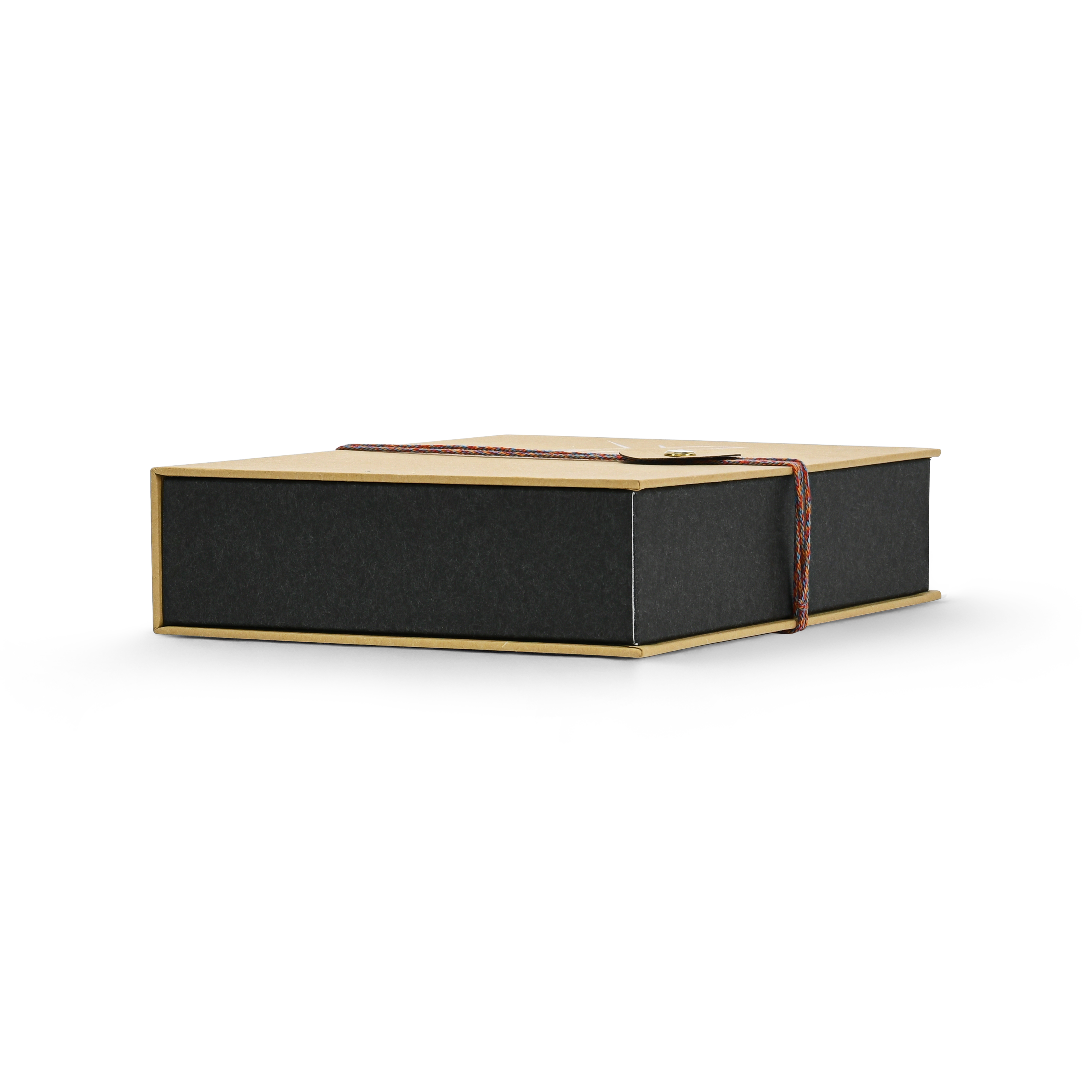 Low angle side view of a closed custom book style perfume gift box highlighting the clean edges of the matte black inner box and the braided rope closure wrapped around the ochre yellow cover