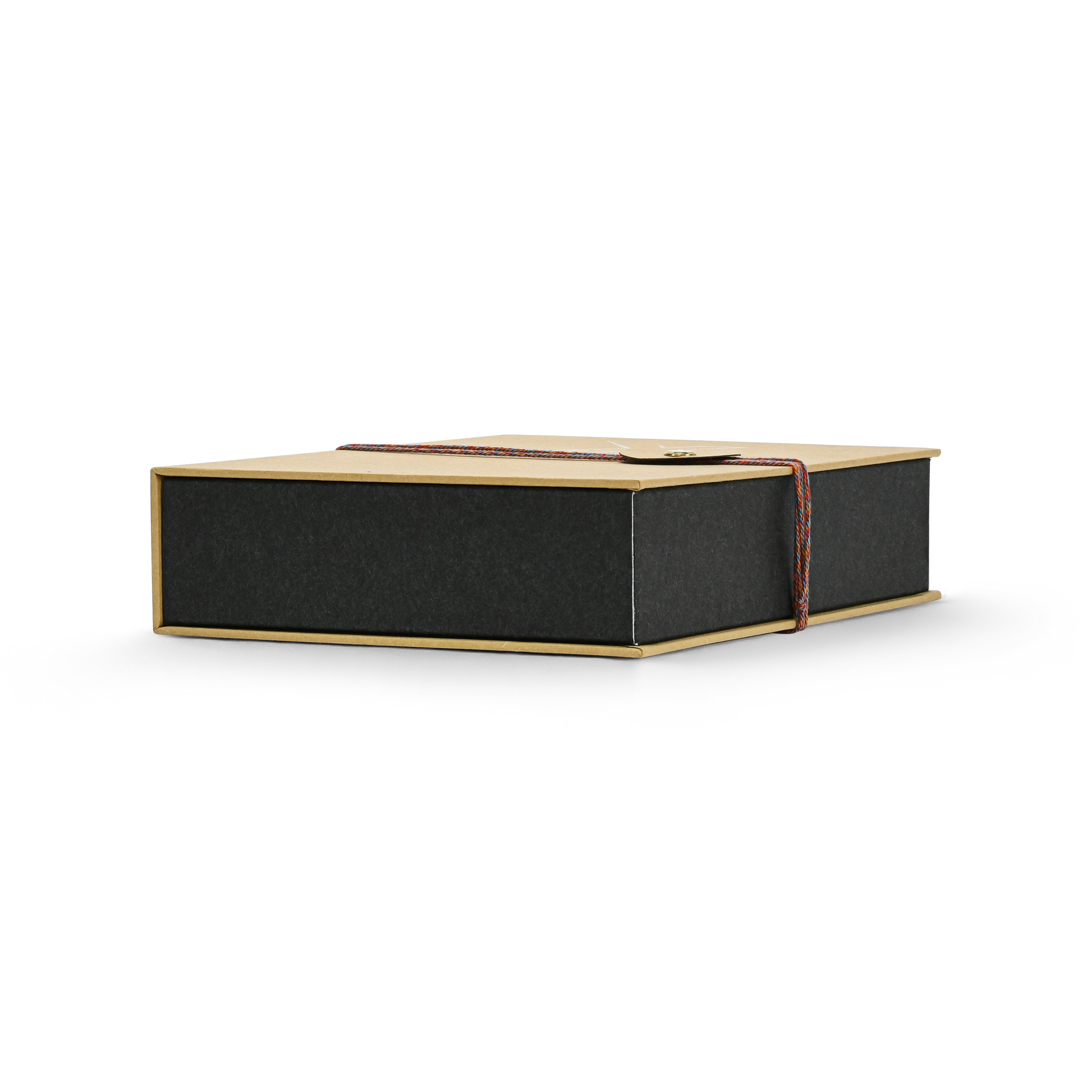 Low angle side view of a closed custom book style perfume gift box highlighting the clean edges of the matte black inner box and the braided rope closure wrapped around the ochre yellow cover
