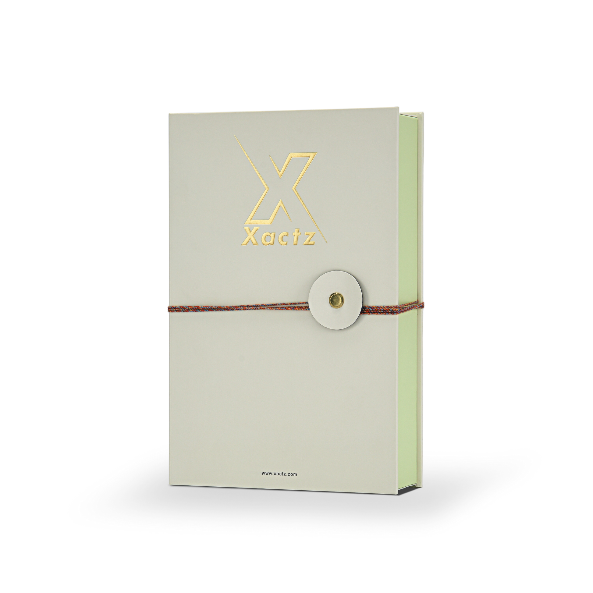 Luxury cream book style perfume gift box three quarter angle view showing embossed gold foil Xactz logo soft-touch matte lamination pale green interior spine and multicolour rope closure with gold metal rivet